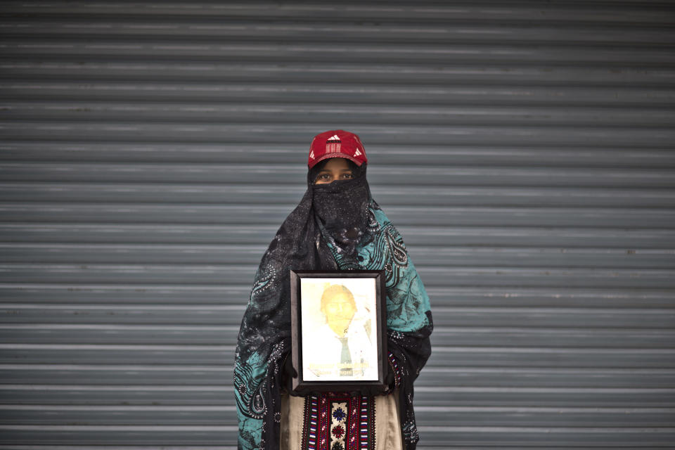 Zareena Qalandrani poses for a portrait holding a photograph of her brother Manzoor, who went missing on August 2, 2012, while she and other relatives take a break from a long march protest, in Rawalpindi, Pakistan, Friday, Feb. 28, 2014. She is part of a group of activists from the impoverished southwestern province of Baluchistan who walked roughly 3,000 kilometers (1,860 miles) to the capital of Islamabad to draw attention to alleged abductions of their loved ones by the Pakistani government. (AP Photo/Muhammed Muheisen)