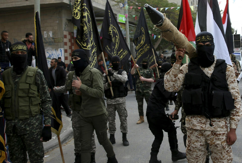 FILE - In this Dec. 22, 2017 file photo, masked members of the Palestinian Al-Quds Brigades, the military wing of the Islamic Jihad group, march with their rifles during a protest against U.S. President Donald Trump's decision to recognize Jerusalem as Israel's capital, in Nusseirat refugee camp, central Gaza Strip. From Lebanon and Syria to Iraq, Yemen, and the Gaza Strip, Iran has significantly expanded its footprint over the past decade, finding and developing powerful allies in conflict-ravaged countries across the Middle East. (AP Photo/Adel Hana, File)