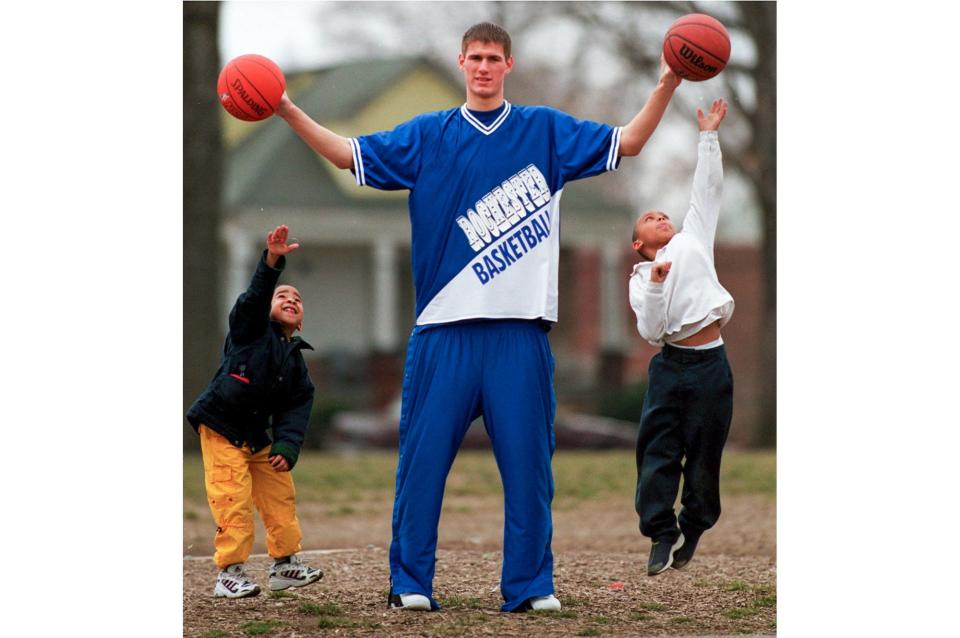 The 6-foot-11 Mr. Basketball for the state of Michigan, Paul Davis from Rochester High School, proves to be a tall order for Amari Rose and Steven Bernard, both students at Thurgood Marshall Elementary School, in Detroit as they try to jump for the ball on the schools playground.