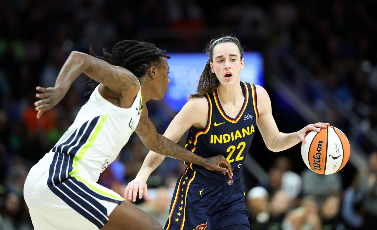 May 3, 2024; Dallas, Texas, USA; Indiana Fever guard Caitlin Clark (22) controls the ball as Dallas Wings forward Natasha Howard (6) defends during the second quarter at College Park Center.