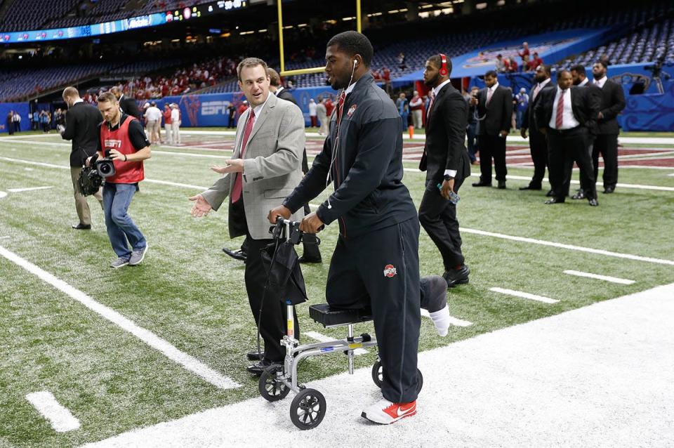 Ohio State Buckeyes offensive coordinator Tom Herman, left, talks with Ohio State Buckeyes quarterback J.T. Barrett (16), right, as they walk on the field before the Allstate Sugar Bowl and College Football Playoff Semifinal at Mercedes-Benz Superdome in New Orleans, Thursday night, January 1, 2015. Ohio State and Alabama face off to see which team will make it to the National Championship.