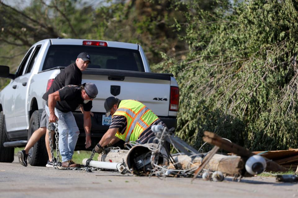 People try to remove a downed utility line from Cimarron Road near NW 10 in Oklahoma City.