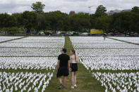 People visit artist Suzanne Brennan Firstenberg's "In America: Remember," a temporary art installation made up of white flags to commemorate Americans who have died of COVID-19, on the National Mall in Washington, Tuesday, Sept. 21, 2021. (AP Photo/Patrick Semansky)
