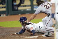 Houston Astros' George Springer, left, scores on a wild pitch as Arizona Diamondbacks starting pitcher Zac Gallen (23) reaches to tag him during the first inning of a baseball game Friday, Sept. 18, 2020, in Houston. (AP Photo/David J. Phillip)