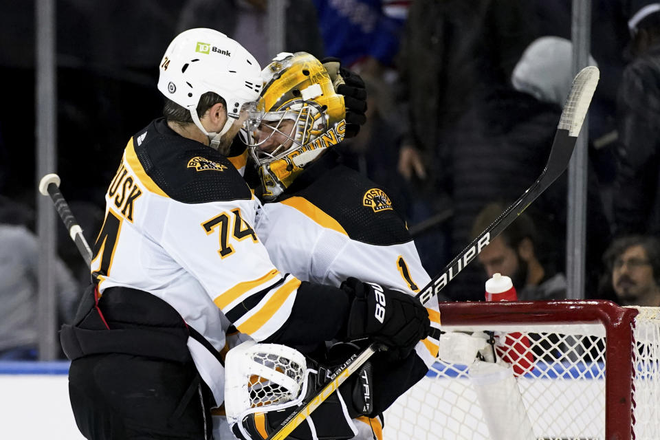 Boston Bruins left wing Jake DeBrusk (74) and goaltender Jeremy Swayman (1) hug after the team's preseason NHL hockey game against the New York Rangers, Wednesday, Oct. 5, 2022, in New York. The Bruins won 5-4. (AP Photo/Julia Nikhinson)