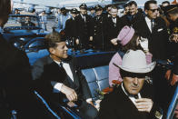 <p>President John F. Kennedy and first lady Jacqueline Kennedy sit in the back of an open-top limousine, along with Texas Gov. John Connally, forming a part of the presidential motorcade at Dallas Love Field airport, Nov. 22, 1963. (Photo: Rolls Press/Popperfoto/Getty Images) </p>