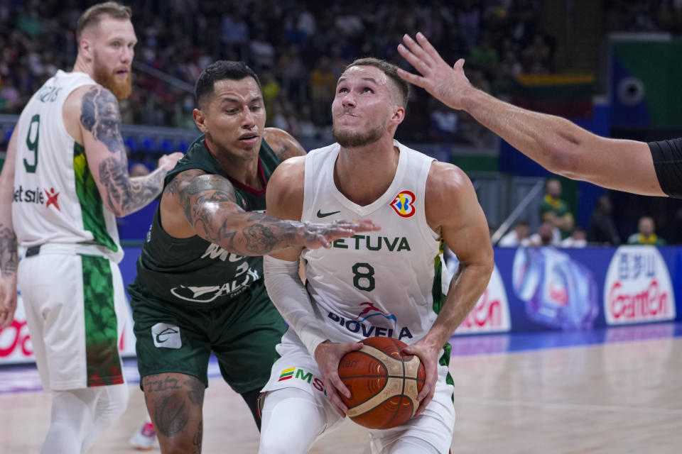 Mexico forward Fabian Jaimes (3) reaches to foul Lithuania forward Tadas Sedekerskis (8) during the first half of a Basketball World Cup group D match in Manila, Philippines Sunday, Aug. 27, 2023. (AP Photo/Michael Conroy)