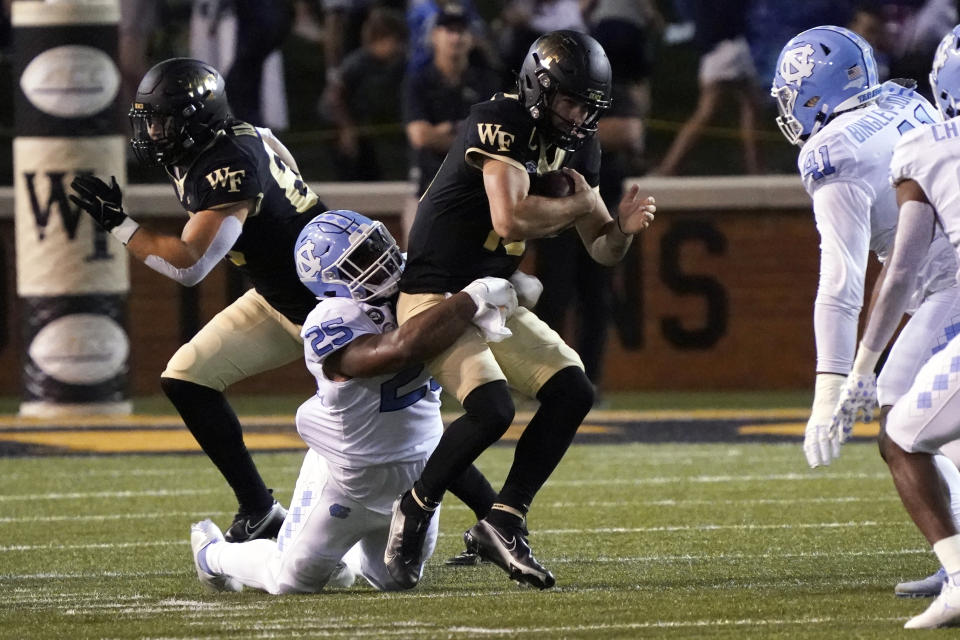 Wake Forest quarterback Sam Hartman (10) is sacked by North Carolina defensive lineman Kaimon Rucker during the first half of an NCAA college football game in Winston-Salem, N.C., Saturday, Nov. 12, 2022. (AP Photo/Chuck Burton)