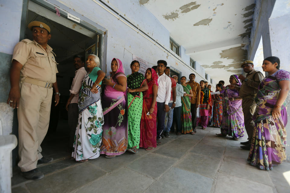 Indians stands in queue to cast their vote for general election in Ahmadabad, India, Tuesday, April 23, 2019. Indians are voting Tuesday in the third phase of the general elections with campaigning by Prime Minister Narendra Modi's Hindu nationalist party and the opposition marred by bitter accusations and acrimony. The voting over seven phases ends May 19, with counting scheduled for May 23. (AP Photo/Ajit Solanki)