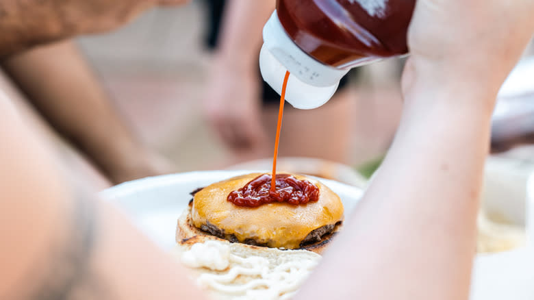 ketchup squeezed onto a cheeseburger