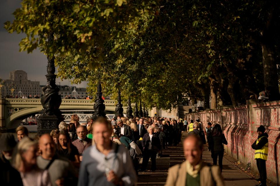 Members of the public stand in line, adjacent to Tower Bridge, to pay their respects to the late Queen Elizabeth II. Hundreds of thousands of people are expected to file past her coffin to pay their respects.