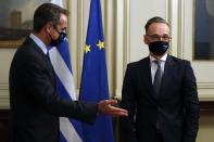 Greece's Prime Minister Kyriakos Mitsotakis, left, welcomes Germany's foreign minister Heiko Maas during their meeting at Maximos Mansion in Athens, Tuesday, Oct. 13, 2020. Maas on Tuesday criticized Turkey for "unilateral steps" in the eastern Mediterranean that are undercutting efforts to de-escalate tensions with Greece and Cyprus over sea boundaries and drilling rights. (AP Photo/Thanassis Stavrakis)