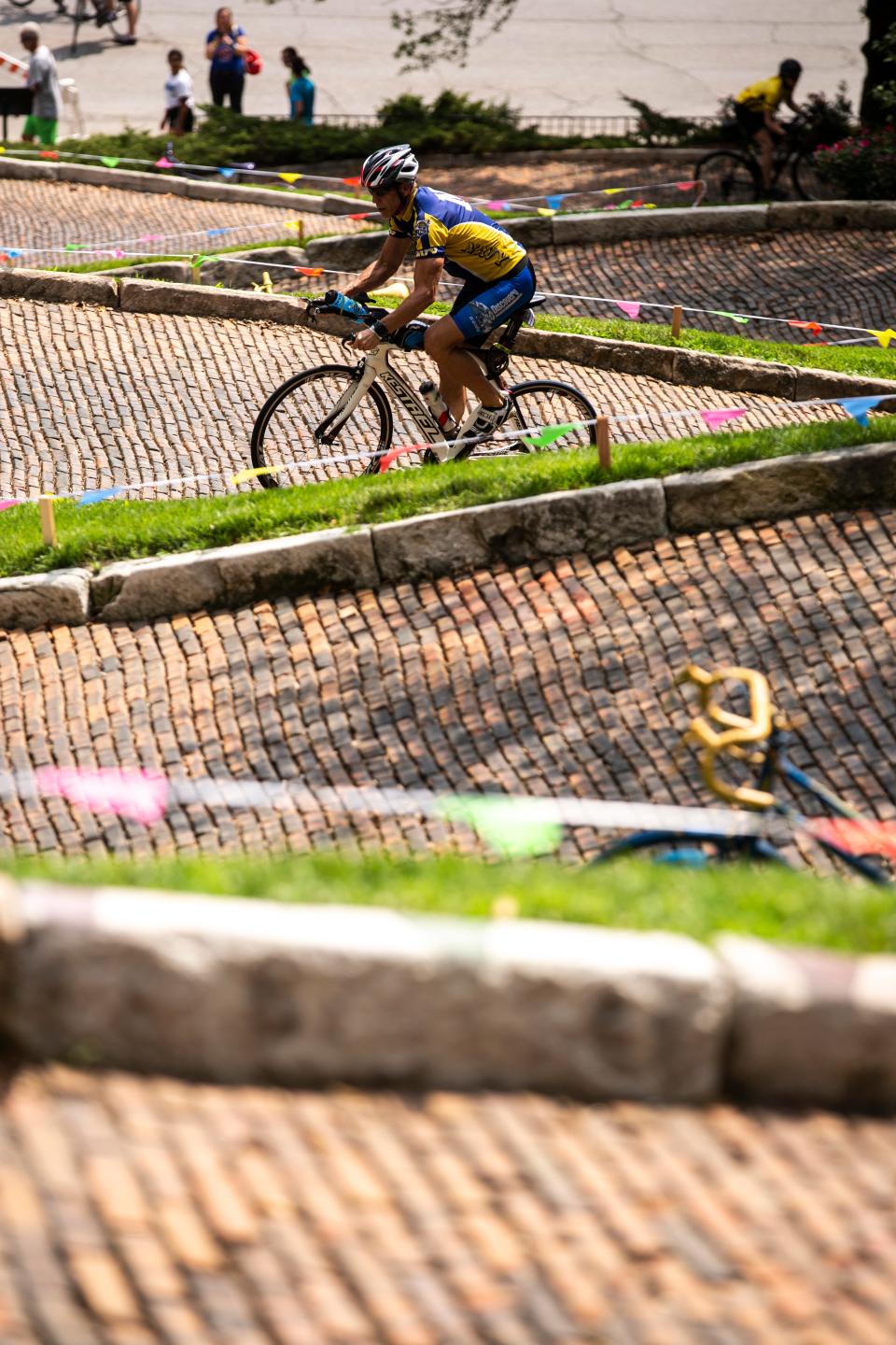 Riders power their way up a 21% grade while completing the Rally to the Alley challenge during RAGBRAI on Day 6 in 2019 along Burlington's Snake Alley.