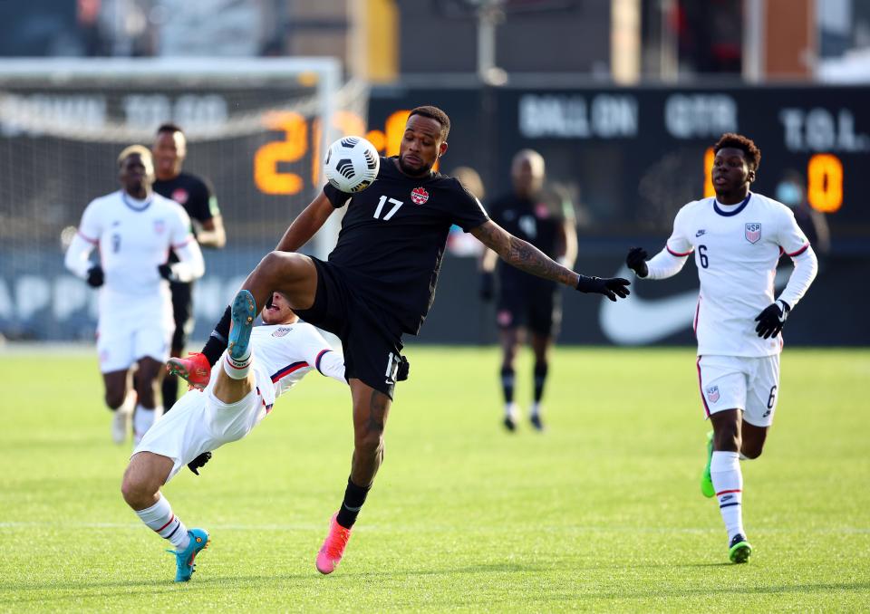 HAMILTON, ON - JANUARY 30: Cyle Larin #17 of Canada and Sergiño Dest #2 of the United States battle for the ball during a 2022 World Cup Qualifying match at Tim Hortons Field on January 30, 2022 in Hamilton, Ontario, Canada.