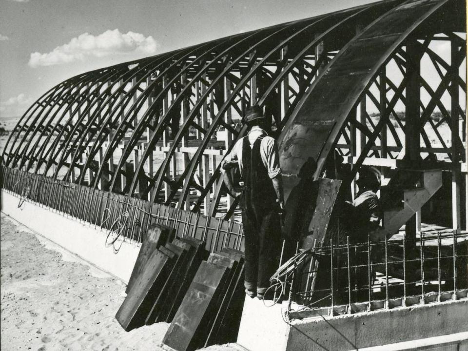 Men work on steel shelters.