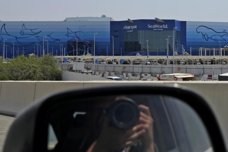 A photographer takes a picture of SeaWorld at the Yas Island in Abu Dhabi, United Arab Emirates, on May 26, 2023. A decade after the outcry over its treatment of captive killer whales nearly put SeaWorld out of business, the company has opened a massive new marine life park in the United Arab Emirates, its first venture outside the United States. A $1.2 billion venture with state-owned developer Miral features the world's largest aquarium and cylindrical LED screen, as well as state-of-the-art facilities housing dolphins, seals, and other animals. (AP Photo/Nick ElHajj)