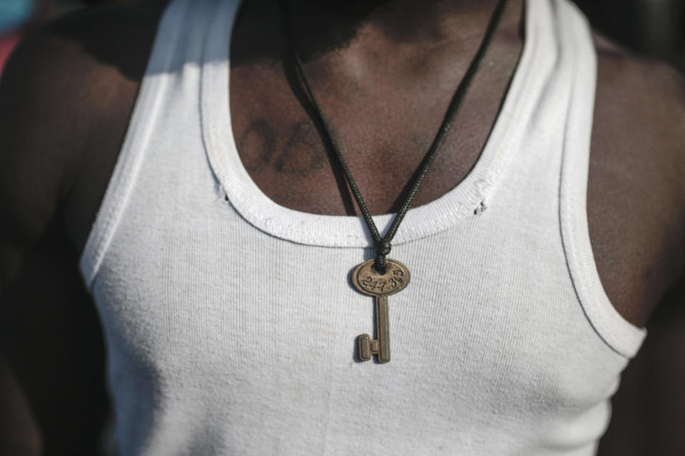 A sub-Saharan poses with a key necklace at Ouled Ziane camp in Casablanca, Morocco, Thursday, Dec. 6, 2018. As Morocco prepares to host the signing of a landmark global migration agreement next week, hundreds of migrants are languishing in a Casablanca camp rife with hunger, misery and unsanitary conditions. These sub-Saharan Africans who dream of going to Europe are a symbol of the problems world dignitaries are trying to address with the U.N.'s first migration compact. (AP Photo/Mosa'ab Elshamy)