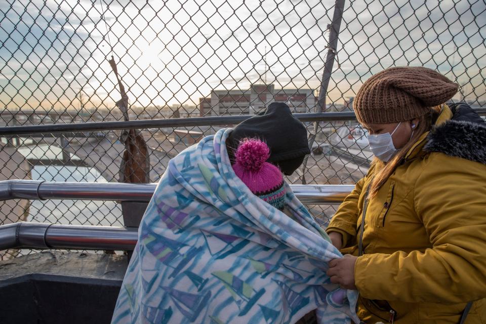 In this file photo from early 2021, after two years of waiting in Mexico under MPP, a migrant from Guatemala and her two children hope to be able to finally enter the U.S. at the Paso del Norte bridge in Ciudad Juárez, Mexico.