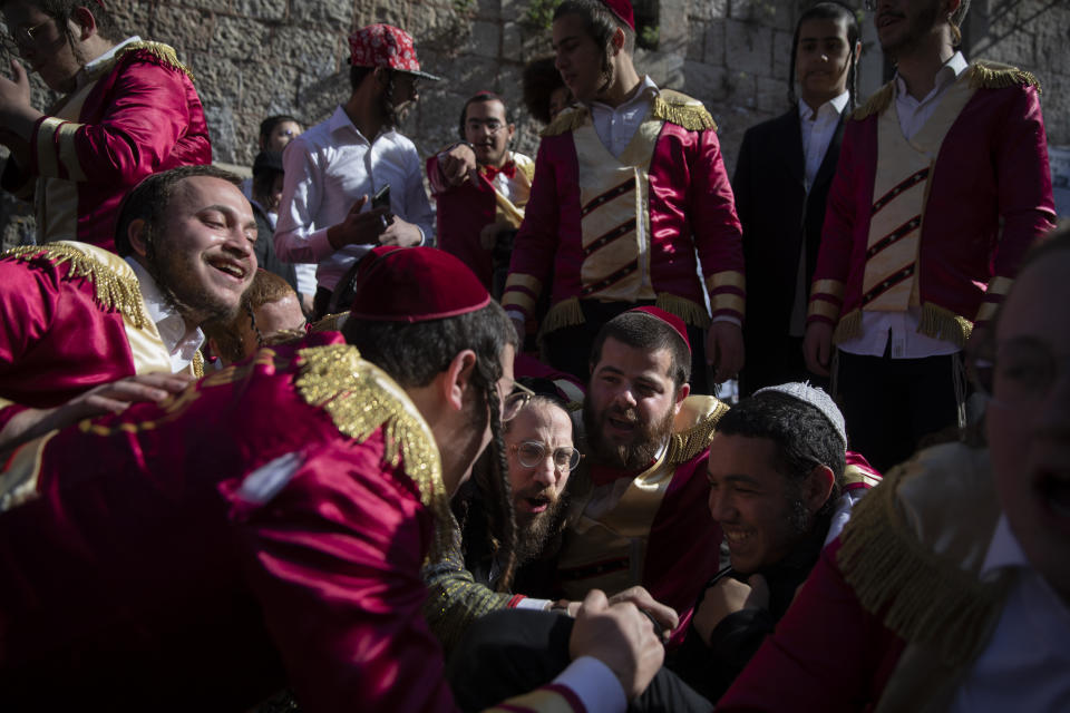 Ultra-Orthodox Jews celebrate after drinking alcohol during the Jewish holiday of Purim, in the Mea Shearim ultra-Orthodox neighborhood of Jerusalem, Sunday, Feb. 28, 2021. The Jewish holiday of Purim commemorates the Jews' salvation from genocide in ancient Persia, as recounted in the biblical Book of Esther. (AP Photo/Oded Balilty)