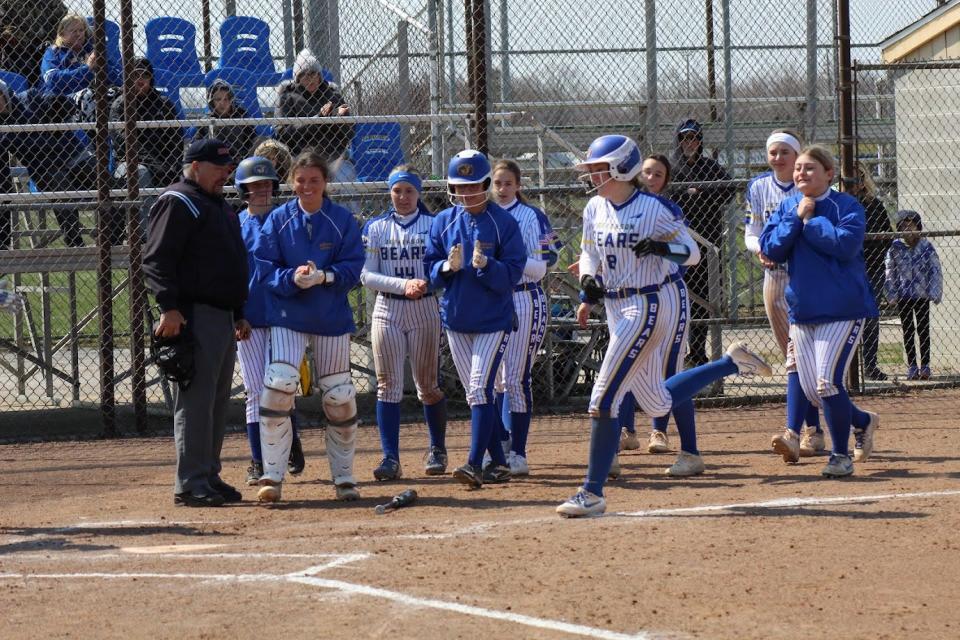 Jefferson’s softball players wait for Gracie Jones at home plate after she hit a home run during a victory over Hazel Park Saturday.