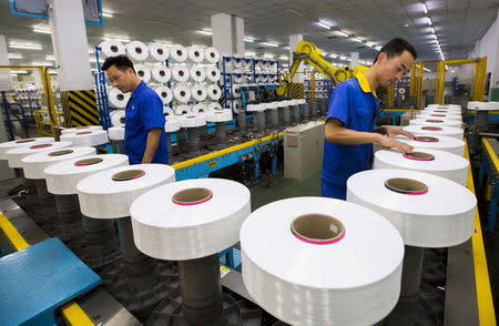 Employees work along a production line of a textile factory in Suzhou, Jiangsu province, China, June 13, 2015. REUTERS/China Daily/Files