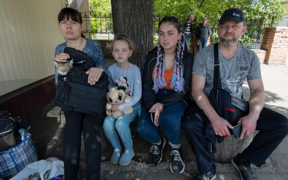 The Cherkasov family with their cat wait for a bus to evacuate them from the area - David Rose for The Telegraph