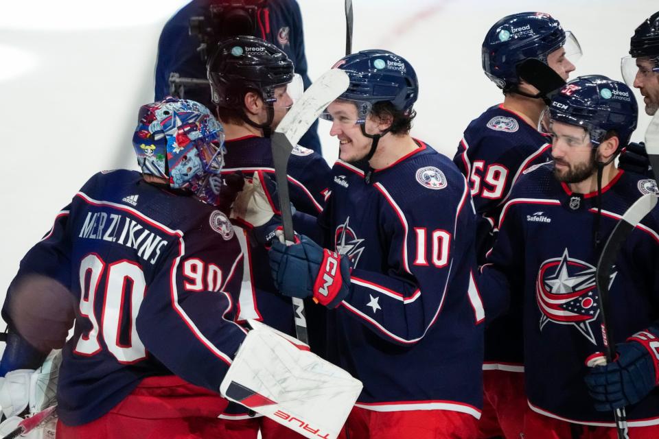Jan 15, 2024; Columbus, Ohio, USA; Columbus Blue Jackets goaltender Elvis Merzlikins (90) celebrates with left wing Dmitri Voronkov (10) following the shootout in the NHL hockey game against the Vancouver Canucks at Nationwide Arena. The Blue Jackets won 4-3.