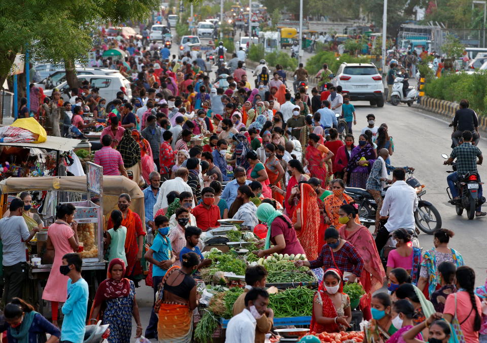 People shop at a crowded roadside vegetable market after authorities eased coronavirus restrictions, following a drop in COVID-19 cases in Ahmedabad, India, June 15, 2021. REUTERS/Amit Dave