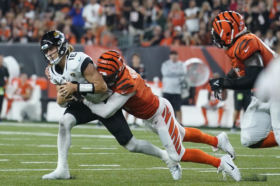 Jacksonville Jaguars quarterback Trevor Lawrence (16) is tackled by Cincinnati Bengals' Trey Hendrickson (91) on Thursday, Sept. 30, 2021, in Cincinnati.