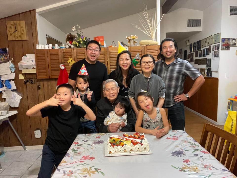 At a family birthday party in 2022 in Long Beach, Calif., Cathy Linh Che stands behind her seated father, Hue Che, and her mother, Hoa Le.