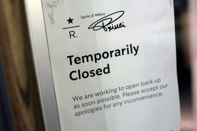 FILE PHOTO: A sign is seen on the door of a temporarily closed Starbucks Reserve location after an employee tested positive for coronavirus in Seattle