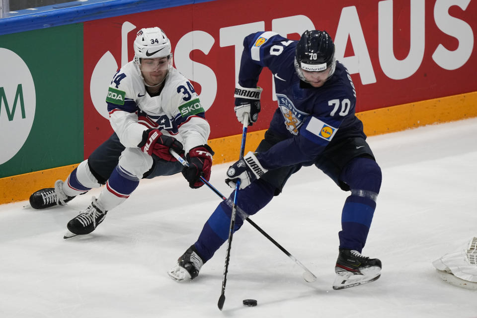 Finland's Teemu Hartikanen and Thomas Bordeleau of the United States work for the puck during a match between Finland and the the United States in the semifinals of the Hockey World Championships, in Tampere, Finland, Saturday, May 28, 2022. (AP Photo/Martin Meissner)