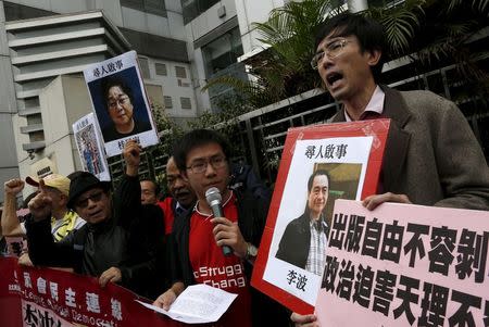 Pro-democracy demonstrators hold up portraits of Causeway Bay Books shareholder Lee Bo (R) during a protest to call for an investigation behind the disappearance of five staff members of a Hong Kong publishing house and bookstore, outside the Chinese liaison office in Hong Kong, China January 3, 2016. REUTERS/Tyrone Siu