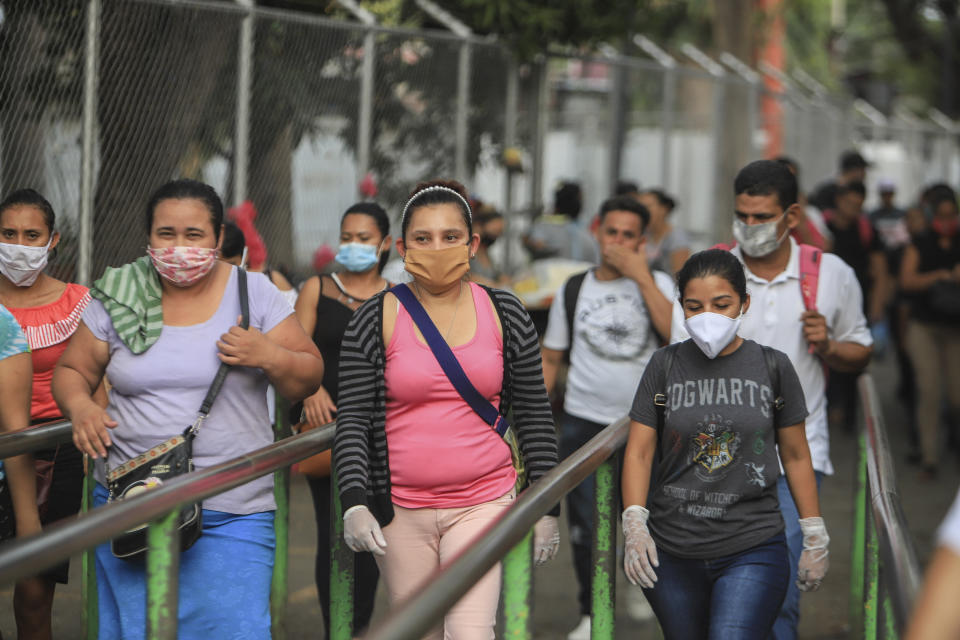 Workers wear masks as a protection against the spread of the new coronavirus as they leave from a day's work in Managua, Nicaragua, Monday, May 11, 2020. President Daniel Ortega's government has stood out for its refusal to impose measures to halt the new coronavirus for more than two months since the disease was first diagnosed in Nicaragua. Now, doctors and family members of apparent victims say, the government has gone from denying the disease's presence in the country to actively trying to conceal its spread. (AP Photo/Alfredo Zuniga)