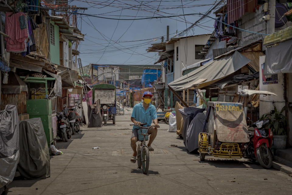 A resident rides a bicycle at an empty alley at a slum community as government imposes lockdown measures to curb the spread of the coronavirus on May 4, 2020 in Manila, Philippines. (Photo by Ezra Acayan/Getty Images)