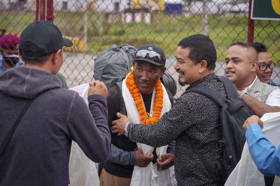 Veteran Sherpa guide Kami Rita, 53, center, who scaled Mount Everest for the 28th time on Tuesday arrives at the airport in Kathmandu, Nepal, Thursday, May 25, 2023. Nepal is getting ready to mark the 70th anniversary of the first ascent of Mount Everest in 1953 by New Zealander Edmund Hillary and his Sherpa guide Tenzing Norgay. (AP Photo/Niranjan Shrestha)