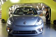 An employee looks at a Volkswagen Beetle car during a ceremony marking the end of production of VW Beetle cars, at company's assembly plant in Puebla