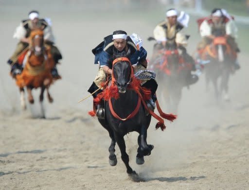 People in samurai costumes ride horses during a horse racing event at the annual "Soma Nomaoi" festival in Minamisoma, Fukushima Prefecture, on July 28. The traditional festival kicked off for the first time since the 2011 quake-tsunami disaster