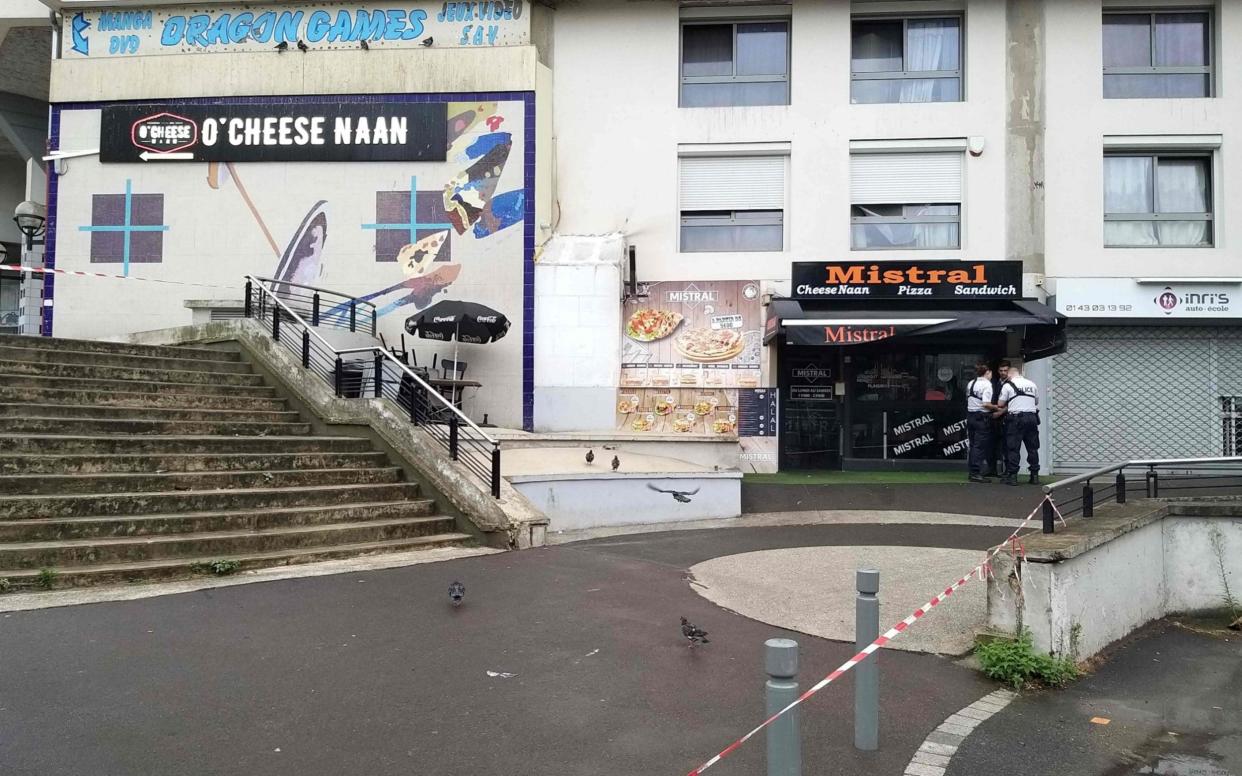 Policemen stand in front of the eatery where a waiter was shot dead by an allegedly angry customer - AFP