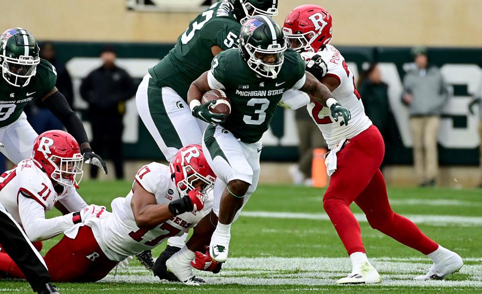 Michigan State running back Jarek Broussard drags Rutgers defenders upfield with him in the first quarter at Spartan Stadium, Nov. 12, 2022.