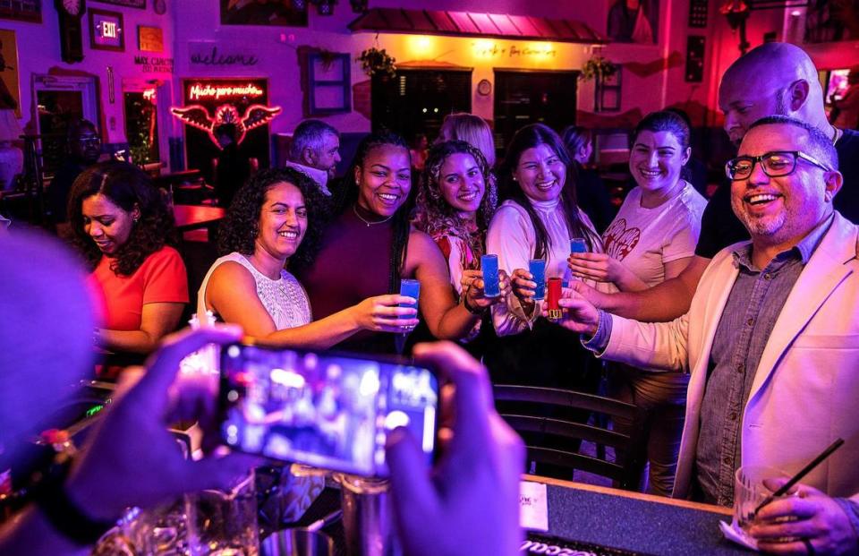 Los clientes brindan con tragos “Blue Kamikaze” preparados por el bartender Carlos Arley García, en Café Mi Vitrola en Miami Lakes, el jueves 03 de febrero de 2023.