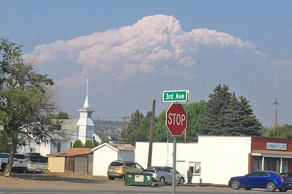 In this photo provided by the Bootleg Fire Incident Command, smoke from the Bootleg Fire rises behind the town of Bonanza, Ore., on Thursday, July 15, 2021. Firefighters scrambled Friday to control a raging inferno in southeastern Oregon that's spreading miles a day in windy conditions, one of numerous wildfires across the U.S. West that are straining resources. The Bootleg Fire, the largest wildfire burning in the U.S., has torched more than 377 square miles (976 square kilometers), and crews had little control of it. (Bootleg Fire Incident Command via AP)