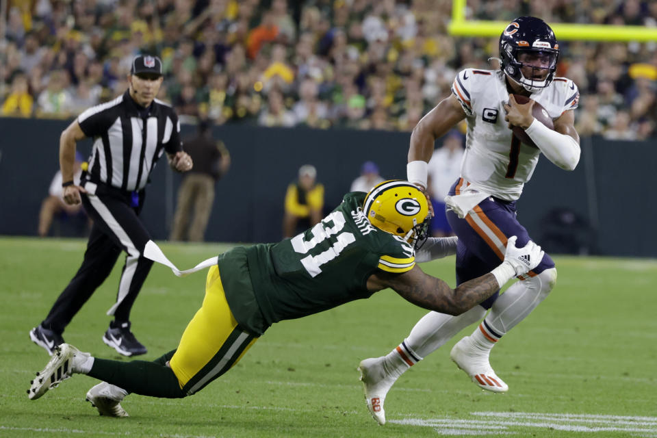 Chicago Bears quarterback Justin Fields (1) tries to break a tackle by Green Bay Packers linebacker Preston Smith (91) during the second half of an NFL football game Sunday, Sept. 18, 2022, in Green Bay, Wis. (AP Photo/Matt Ludtke)