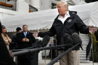 President Donald Trump answers questions from members of the media as he leaves the White House, Saturday Nov. 17, 2018, in Washington, en route to see fire damage in California. At far left is White House press secretary Sarah Huckabee Sanders. (AP Photo/Jacquelyn Martin)