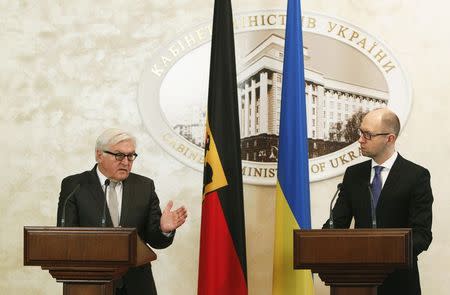 Ukrainian Prime Minister Arseny Yatseniuk (R) listens as German Foreign Minister Frank-Walter Steinmeier speaks during a news conference in Kiev, November 18, 2014. REUTERS/Valentyn Ogirenko