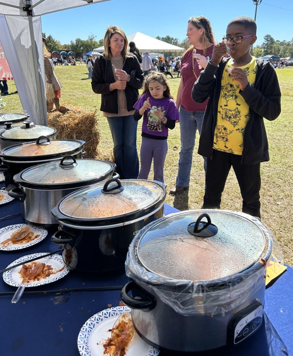 Attendees of the Wrens October Fun Fest sample chili from the contestants.