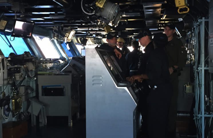 A Navy crew on the flight deck monitors arriving and departing flights.