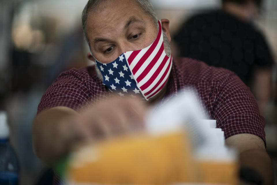 Michigan es uno de los estados más reñidos en estos comicios. Hace cuatro años, el presidente <strong>Donald Trump hizo historia al fracturar la "muro azul" del llamado Cinturón del Óxido (Rust Belt) </strong>y ganar en Michigan, Wisconsin y Pennsylvania. Pero en 2020, las encuestas le daban una ligera ventaja al candidato demócrata Joe Biden. En la imagen el inspector electoral Ron Takala contaba los votos enviados por correo en el City Hall de Warren, en el condado de Macomb, el 3 de noviembre de 2020. (AP Photo/David Goldman)