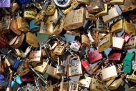 Love locks are fixed on the Pont des Arts Wednesday, April 9, 2014 in Paris. A recent fad among travellers of hitching padlocks on bridges and at tourist attractions worldwide to symbolically immortalize their amorous attraction has swept up this reputed City of Love more than most. Now, two American-born women who live in Paris say they've had enough, launching a petition drive to try to get mostly laissez-faire city officials to step in and do something about what they call an unbearable eyesore in a majestic municipality. (AP Photo/Thibault Camus)