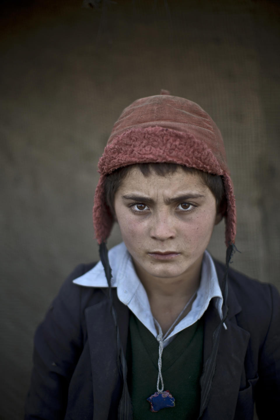 In this Friday, Jan. 24, 2014 photo, Afghan refugee boy, Awal Gul, 12, poses for a picture, while playing with other children in a slum on the outskirts of Islamabad, Pakistan. For more than three decades, Pakistan has been home to one of the world’s largest refugee communities: hundreds of thousands of Afghans who have fled the repeated wars and fighting their country has undergone. Since the 2002 U.S.-led invasion of Afghanistan, some 3.8 million Afghans have returned to their home country, according to the U.N.’s refugee agency. (AP Photo/Muhammed Muheisen)